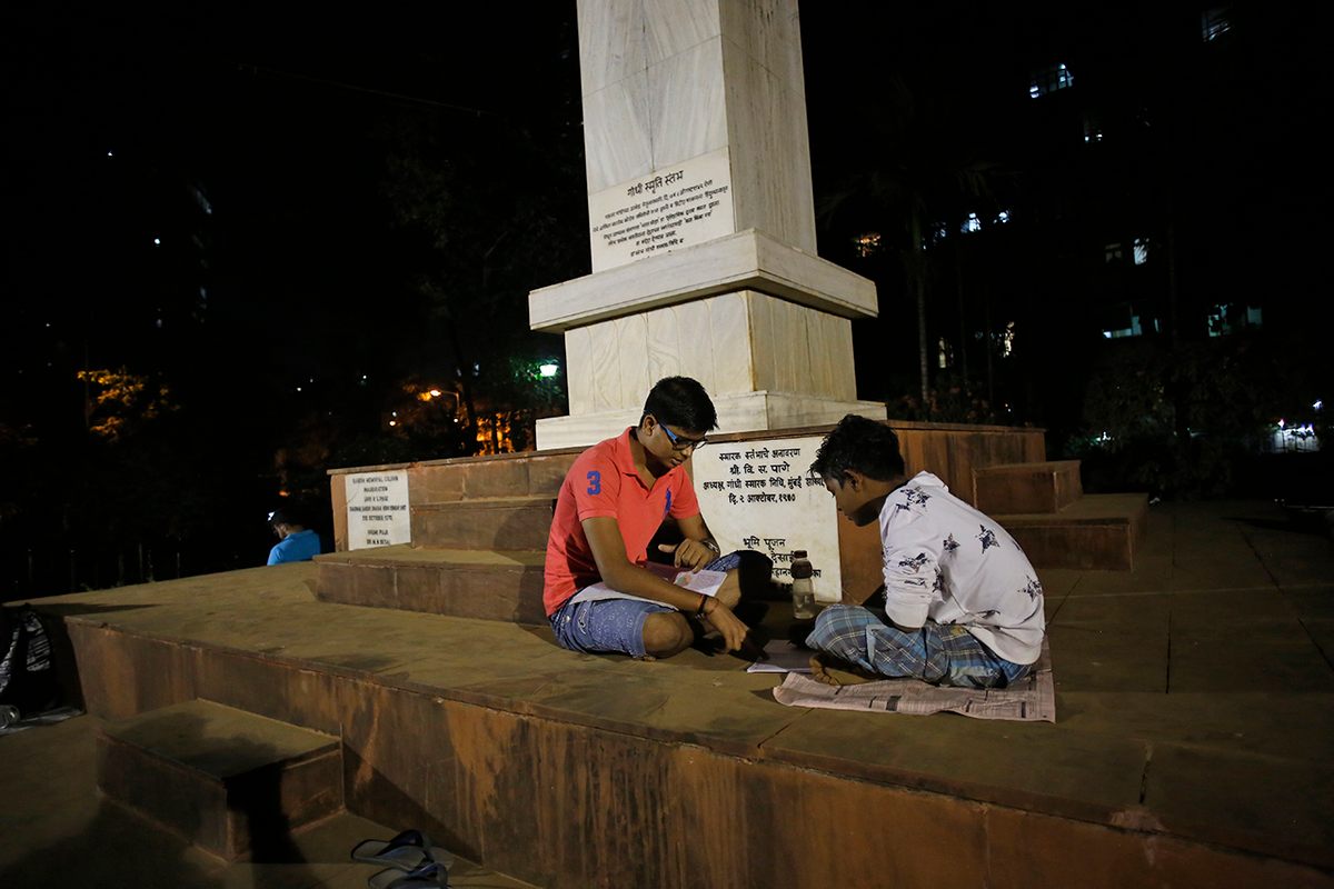 Two students work together at August Kranti Maidan, next to a monument commemorating the spot where Gandhi ordered the British to leave India.