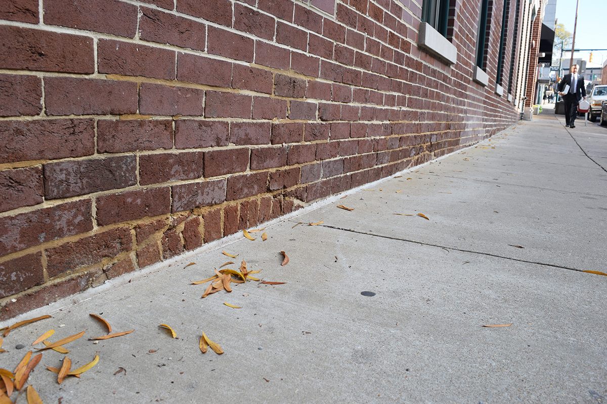 Brickwork disappears past the sidewalk along E 7th Street in Chattanooga.