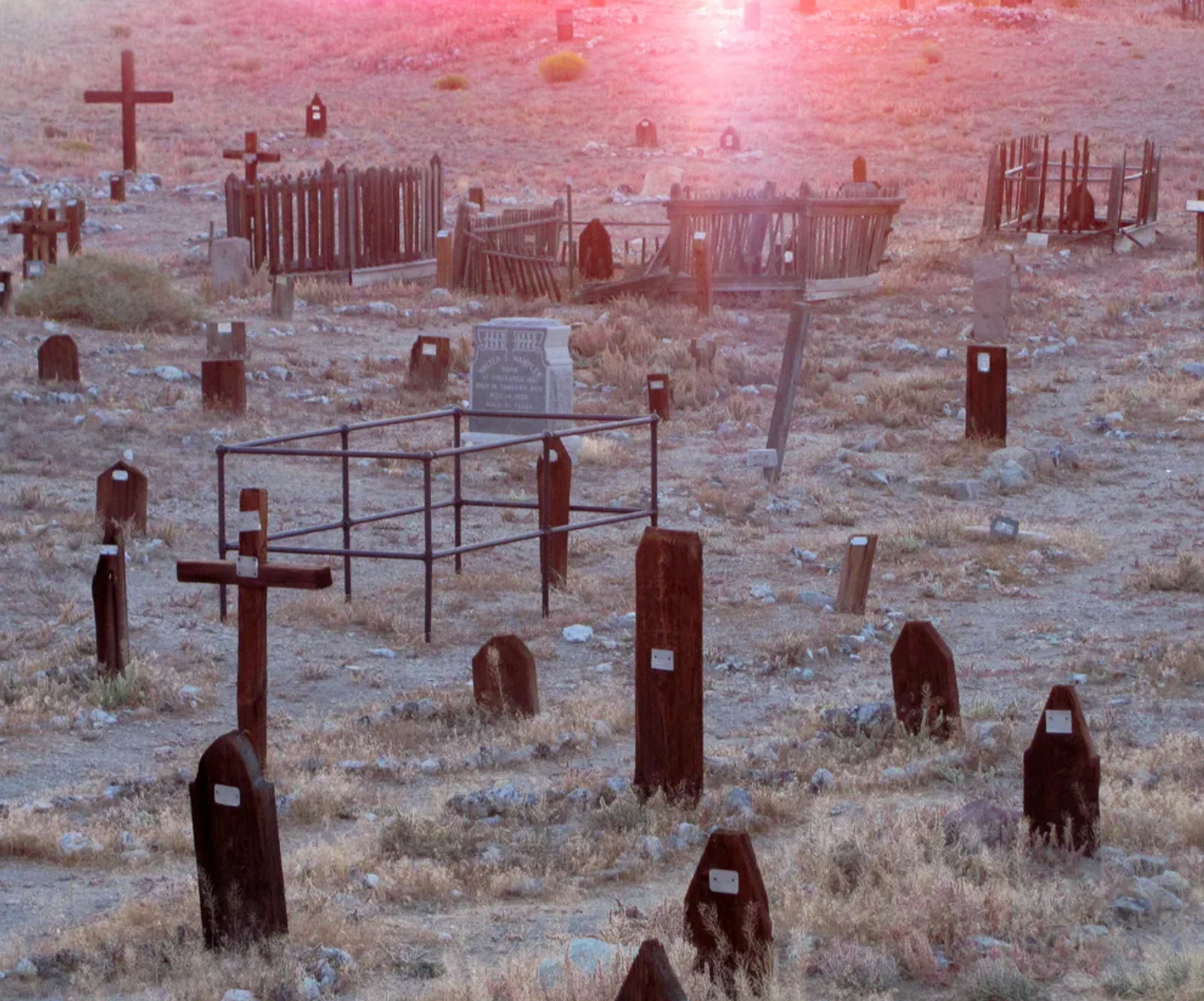 The cemetery is filled with weathered crosses and wooden markers. 