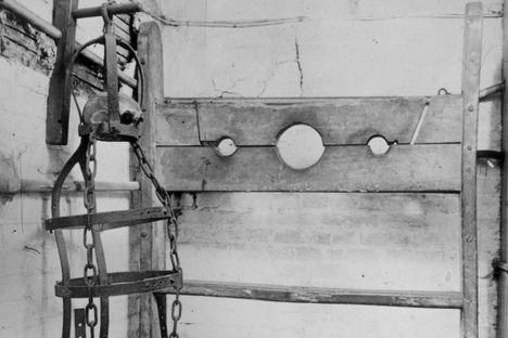 Gibbet irons and stocks on display in Winchelsea town hall in England. Within the gibbet there is a piece of skull belonging to the last man hanged in the equipment. 