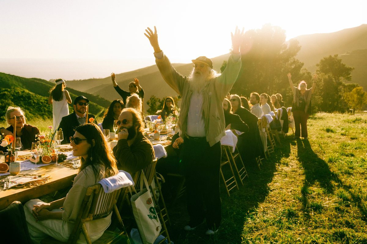 Members of the Source Family blessing the feast table at Gastro Obscura's dinner in 2023.