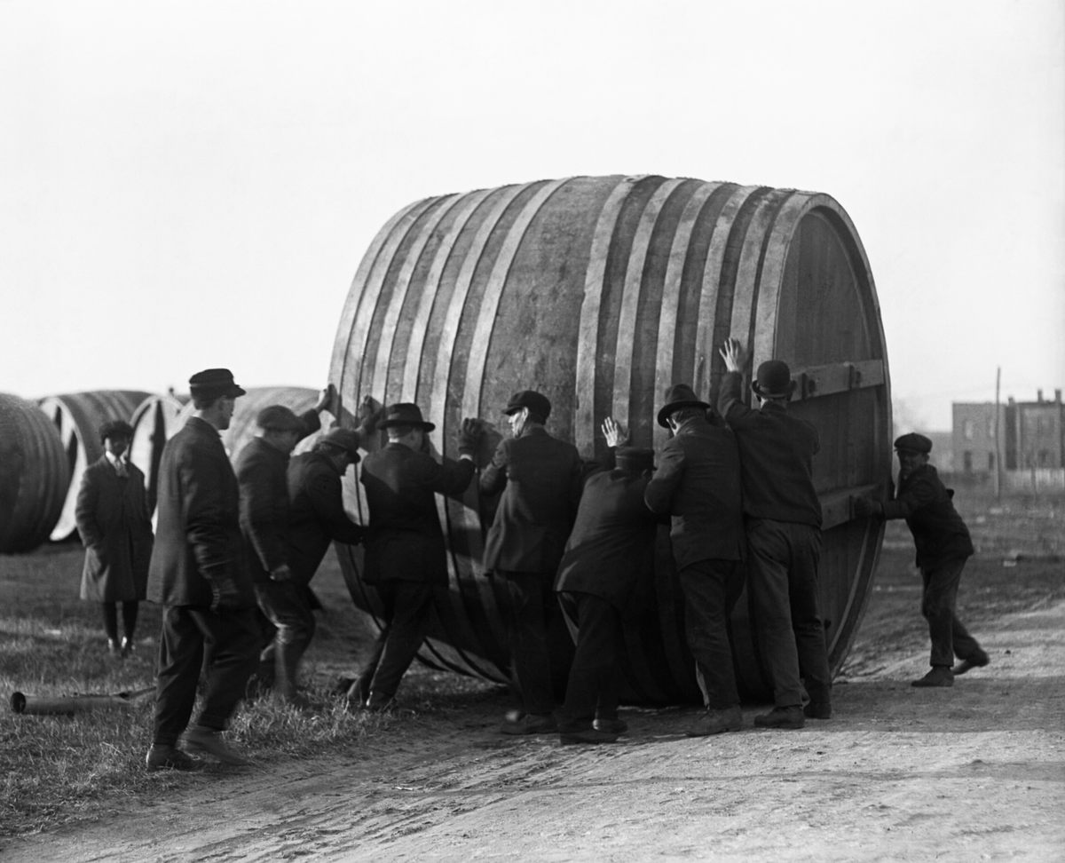 Workers at a Washington, D.C., brewery roll the giant beer vats out to make room for ice cream production equipment.