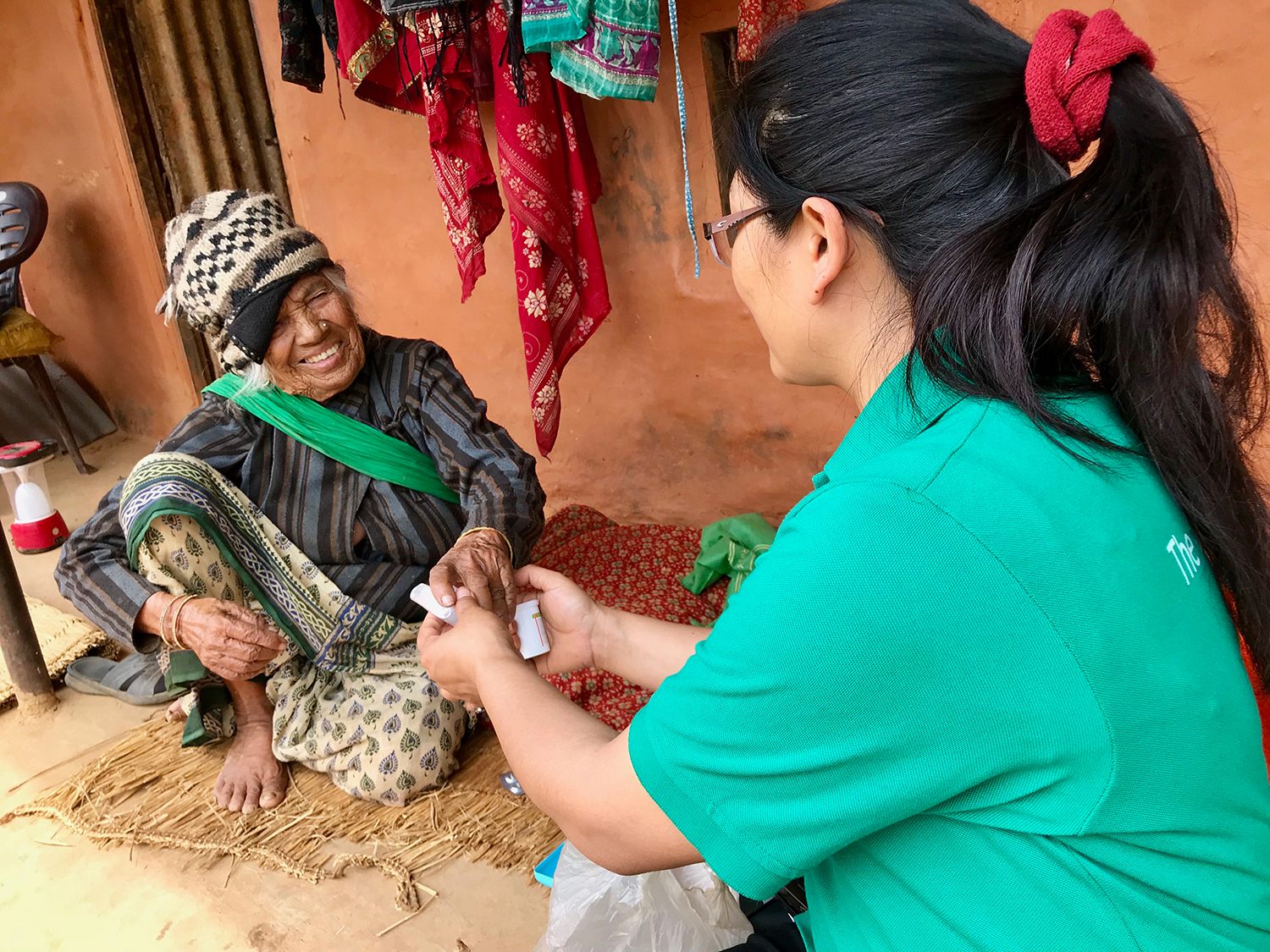 Dr. Tamang consults Kumari on proper use of her inhaler.