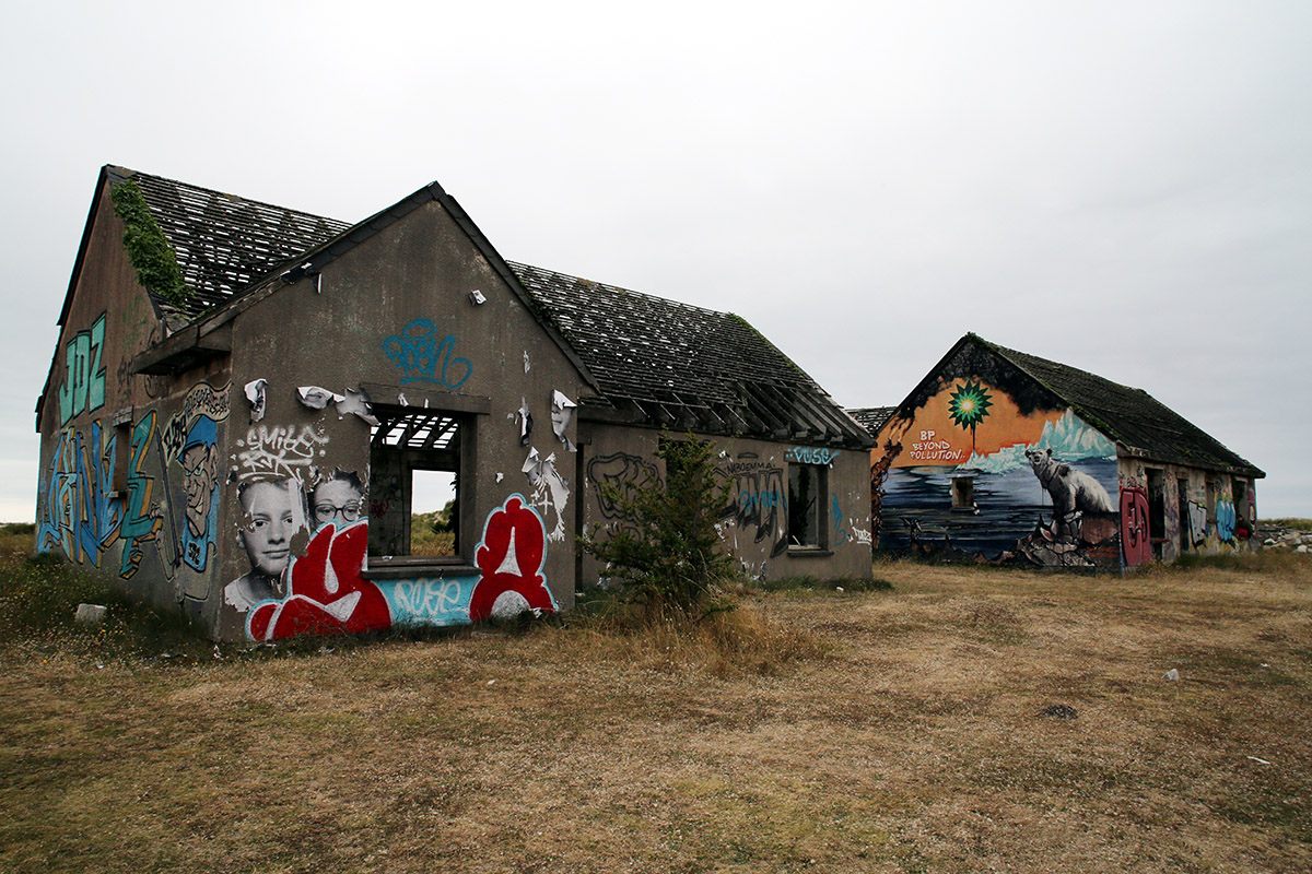 Blown-up portraits by photographer JR glued on houses at Pirou-Plage.