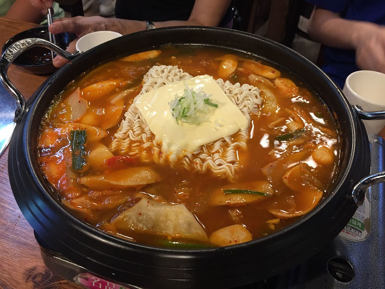 The hodgepodge stew can contain everything from hot dogs to kimchi to sliced cheese.