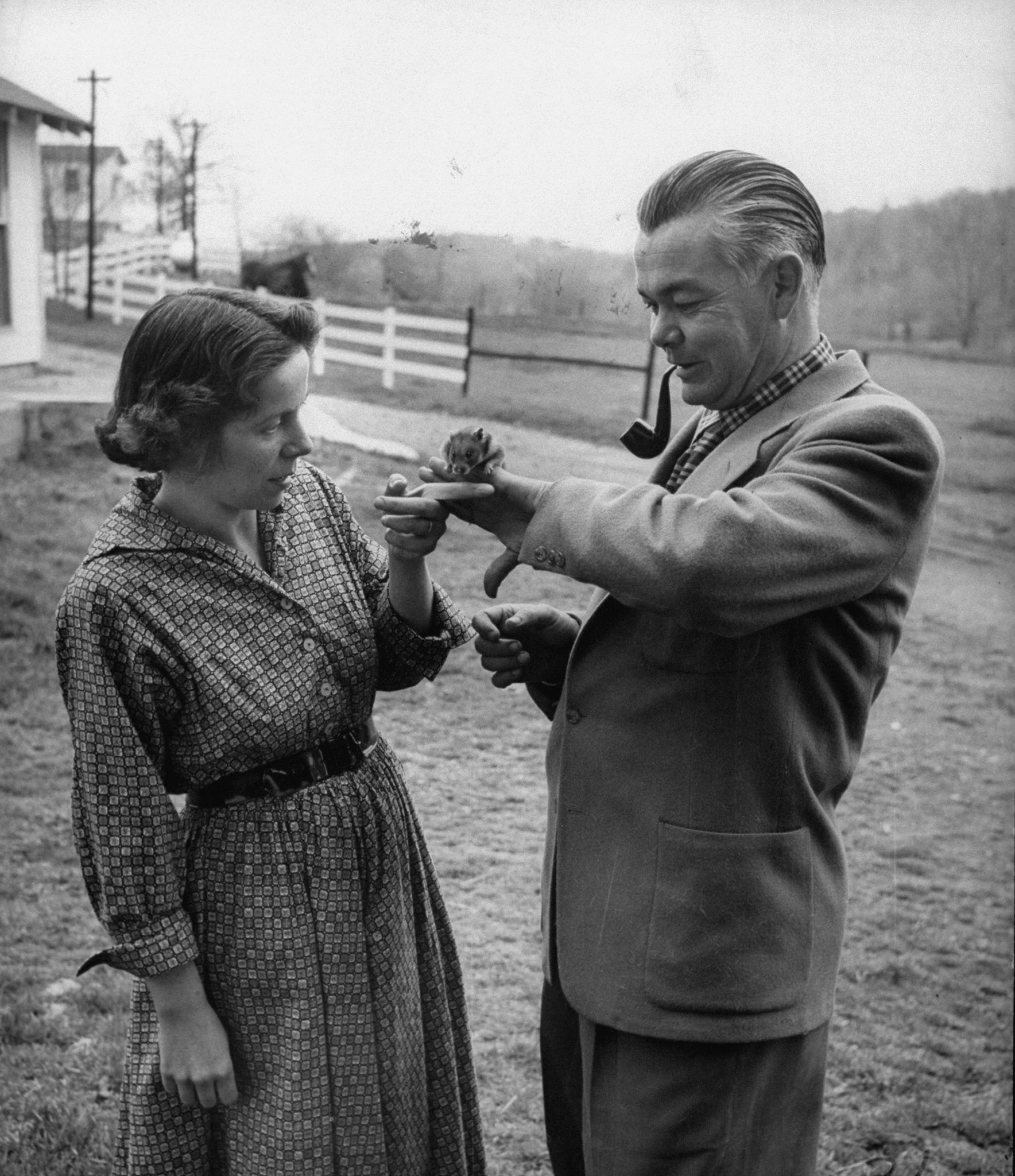 Keller Breland holding a small hamster on his hand while his wife, Marian.