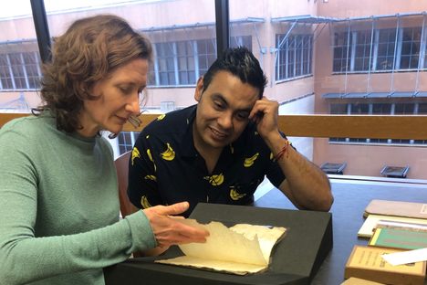Chefs Elizabeth Johnson of Pharm Table in San Antonio and Juan Cabrera Barrón of Fonda Fina in Mexico City page through the collection's oldest book.