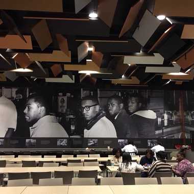 An image of the Greensboro Woolworth lunch counter sit-in illuminates the cafe interior.