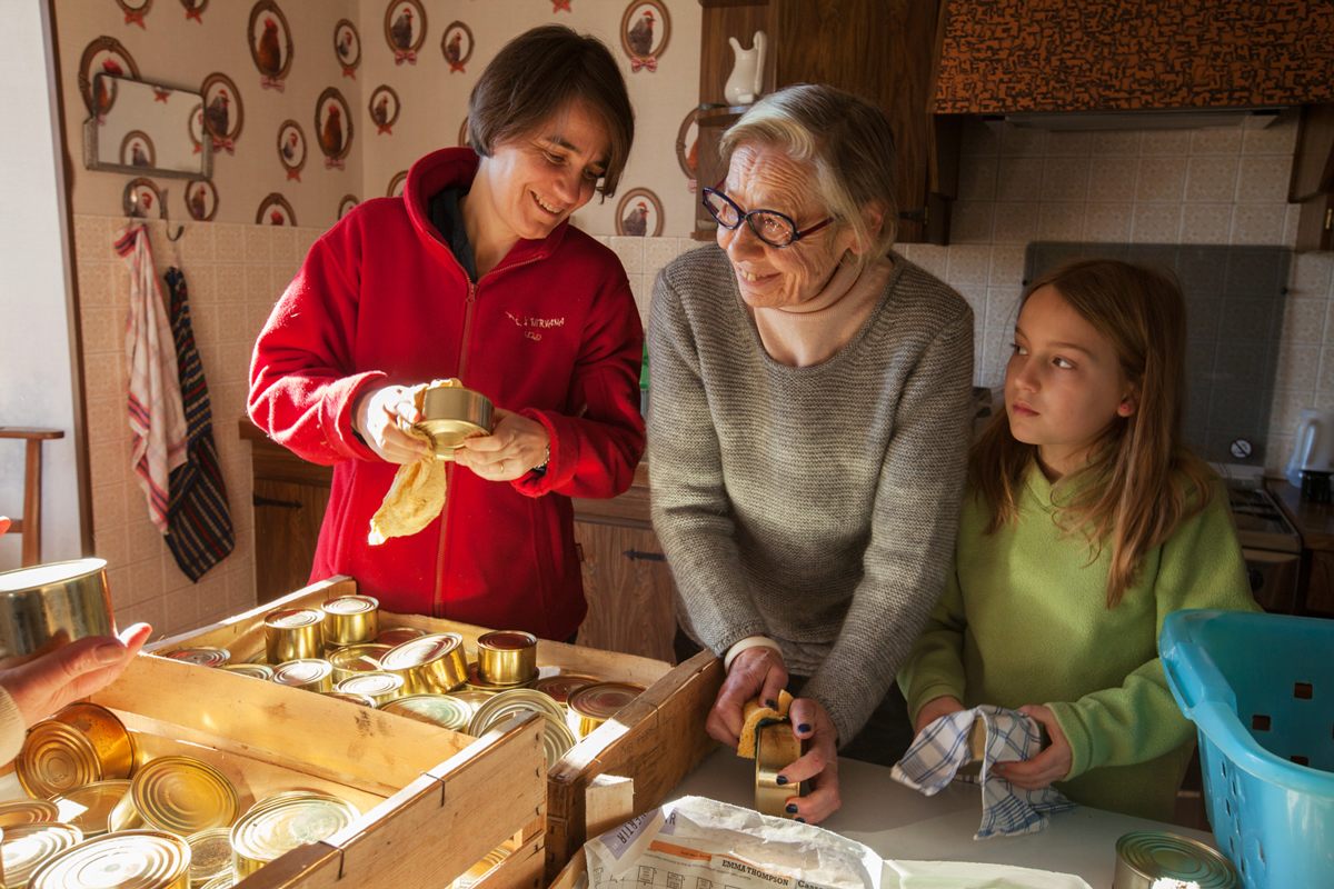 Cécile Bibal, her mother-in-law, Josette, and Cécile's daughter, Suzanne, dry off recently sterilized tins in preparation for making pork pâté.