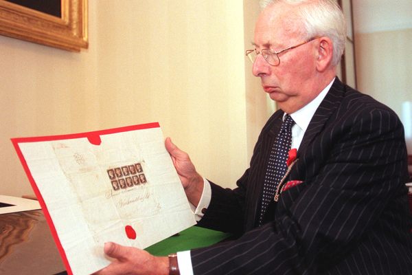 Charles Goodwyn, Keeper of the Royal Philatelic Collection, with copies of world's first stamp