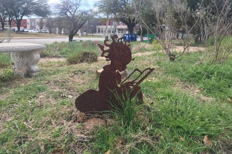 Metal silhouettes of little readers adorn the garden grounds.  