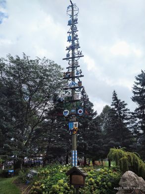A towering maypole surrounded by trees