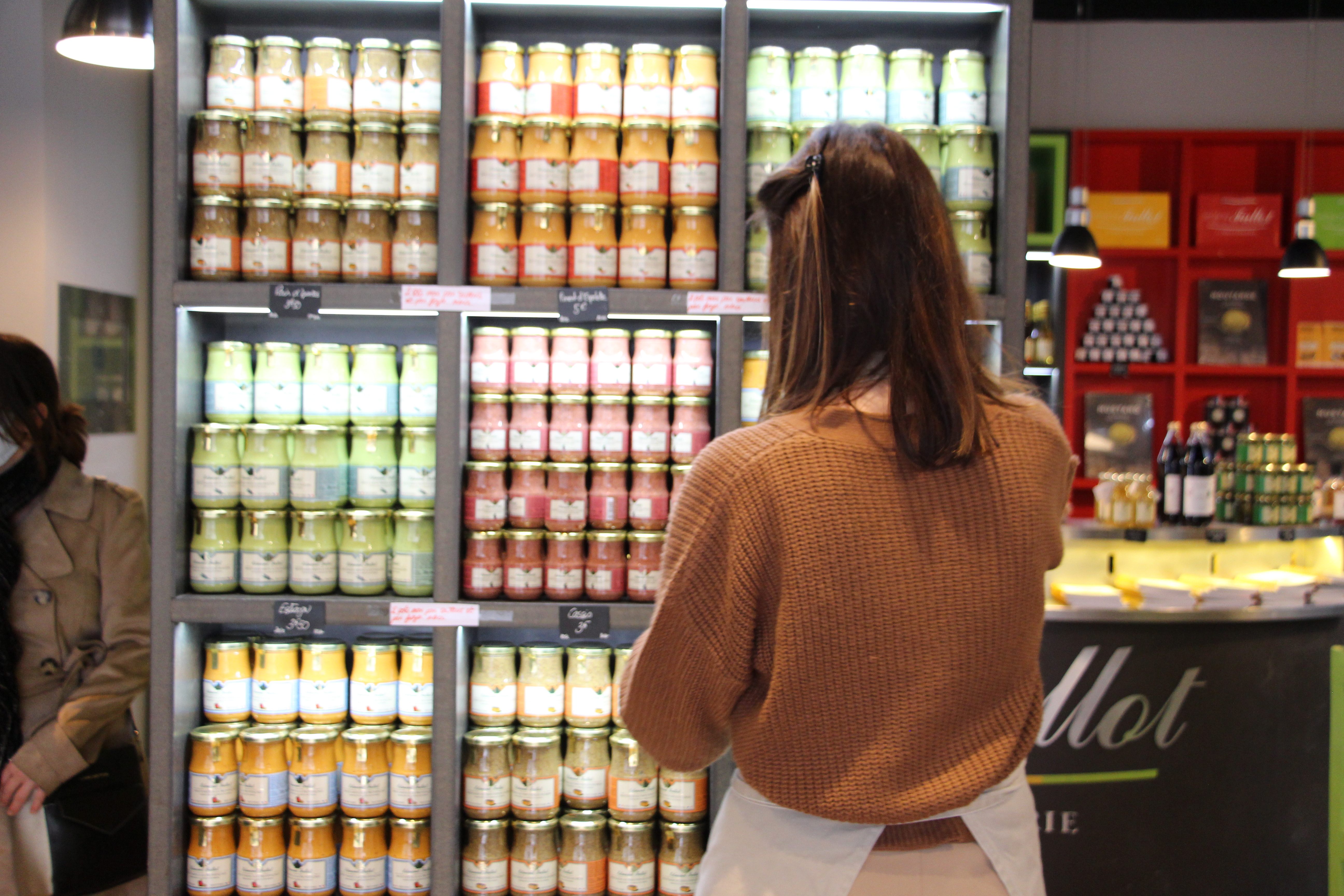 Humbert looks over the array of mustard flavors offered at the store.