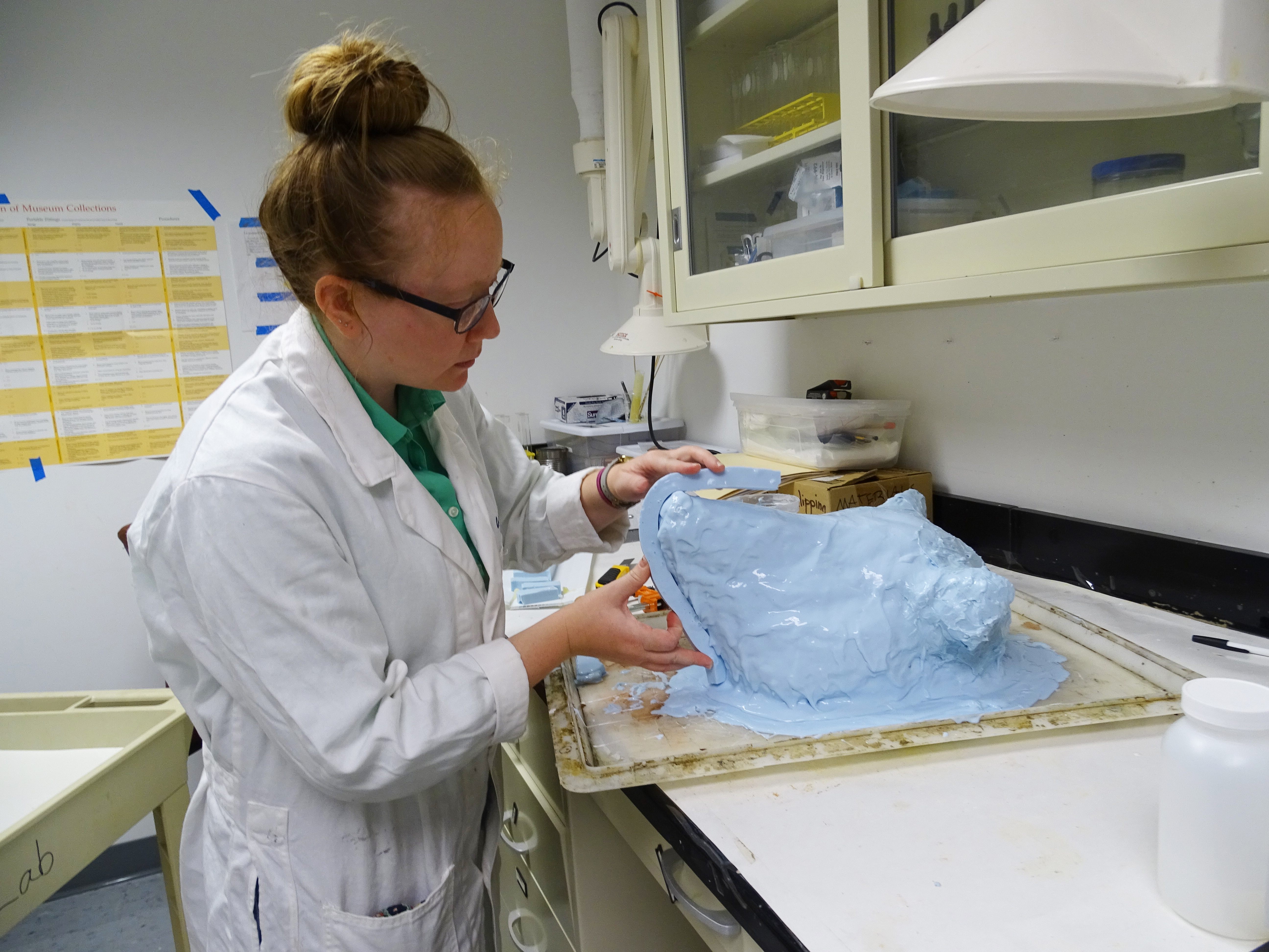 Jennifer Thornton working a mold process with a pig’s head.