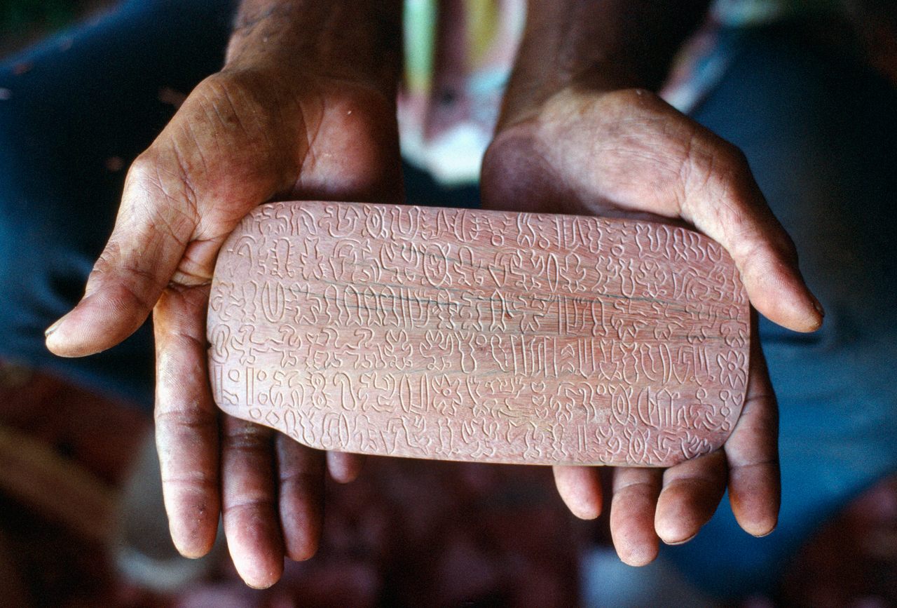 Wood artisan Benedicto Tuki Tepano holding a rongorongo tablet.