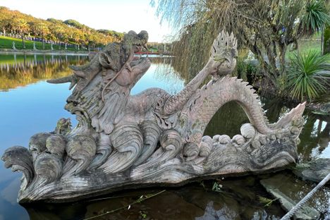A Chinese dragon statue rising from the water.