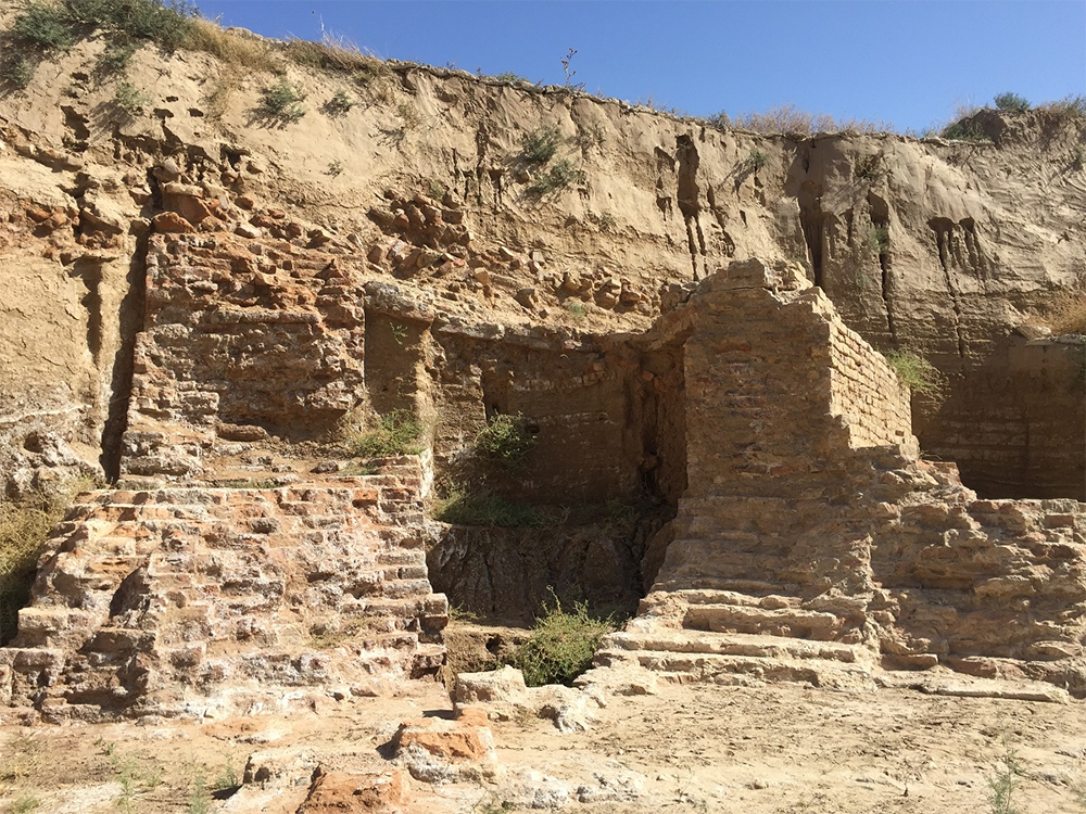 Remains of the wall poke out from under several meters of earth.