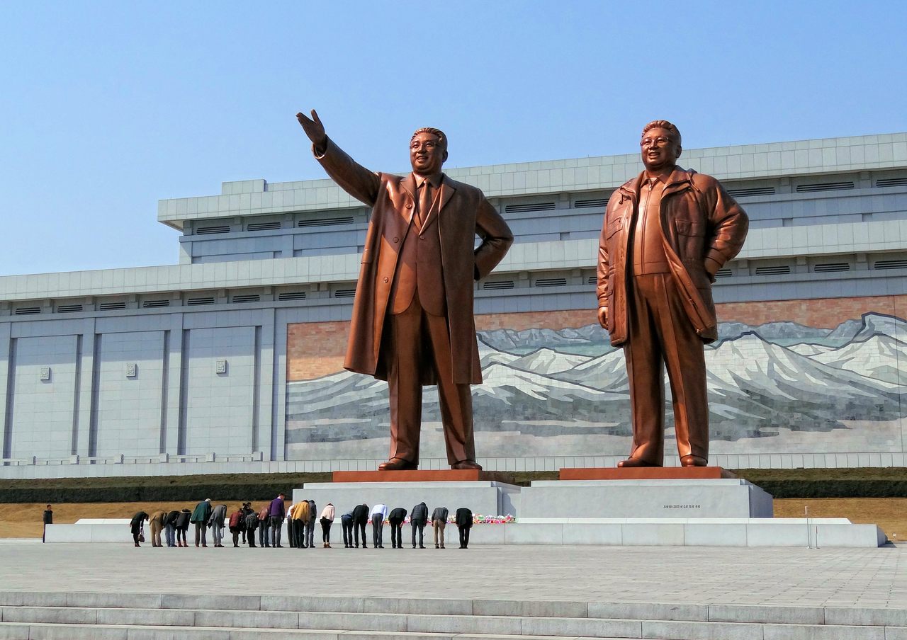 North Korea's late leaders Kim Il-Sung and Kim Jong-Il tower over visitors to the Grand Monument at Mansu Hill, reinforcing the Kim family's power.
