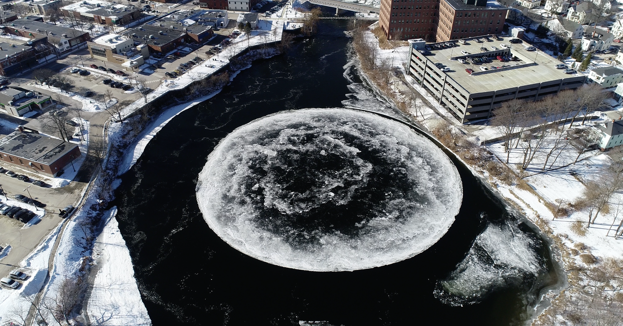 The huge ice disk dwarfs a nearby parking garage.