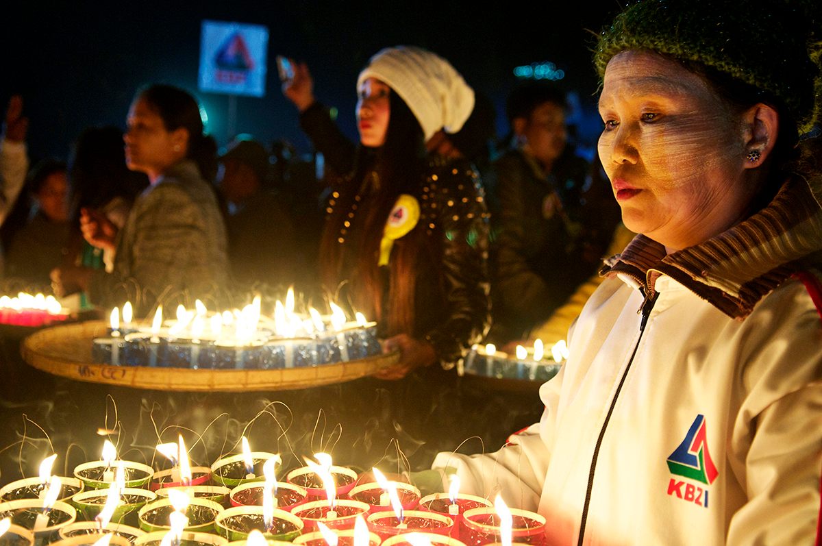 Team members hold candles that will be used to decorate a balloon.