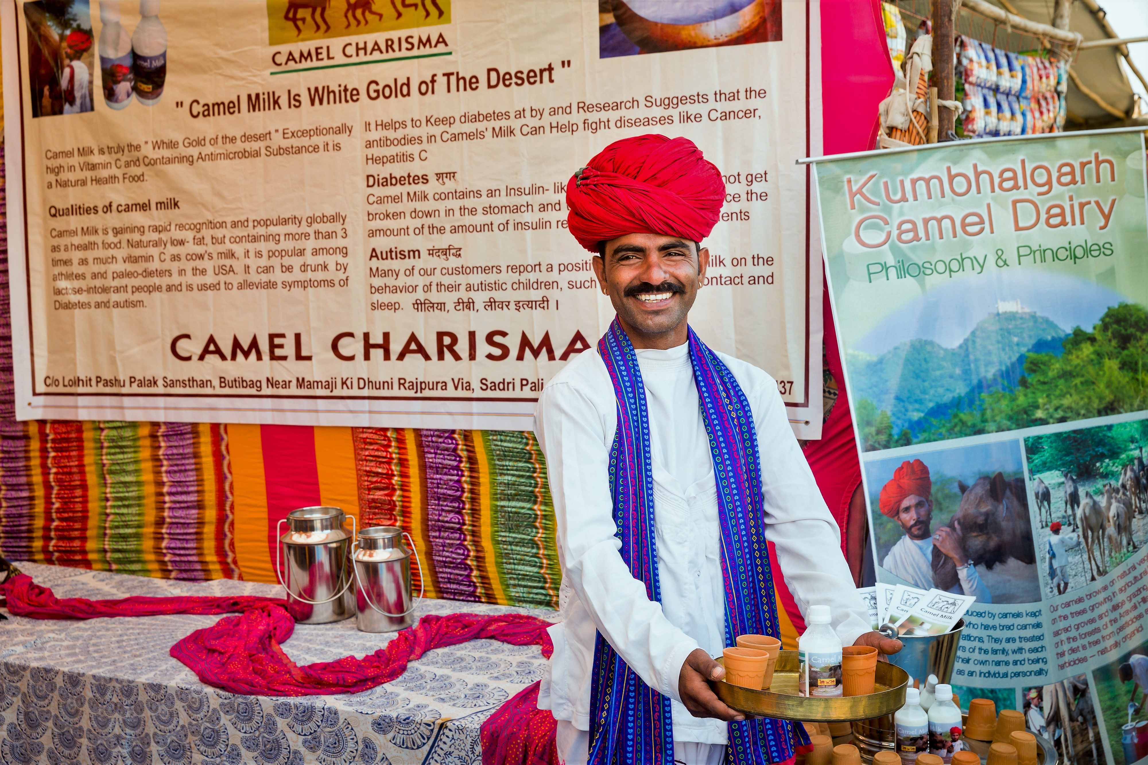 Magan Raika poses in front of an informational display for camel milk.