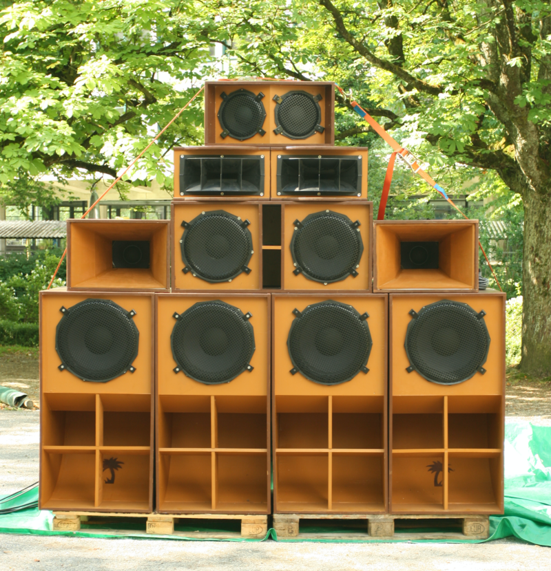 A sound system with four subwoofers on the bottom, one low-frequency box flanked by two mid-frequency horns, two high-frequency sectoral horns, and one mid-high box on top.