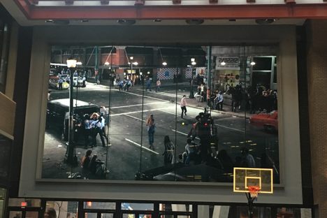 The mural overlooks a basketball court and a public piano.