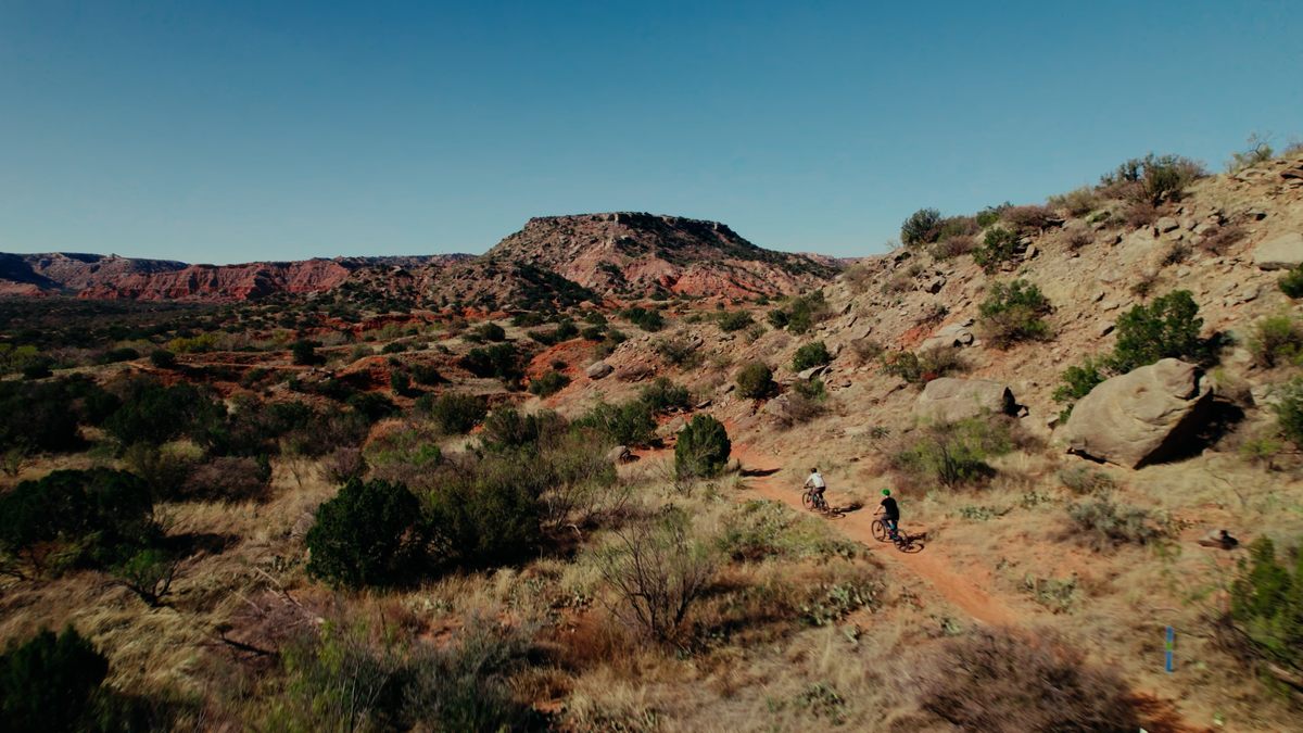 Two bikers on a desert trail.