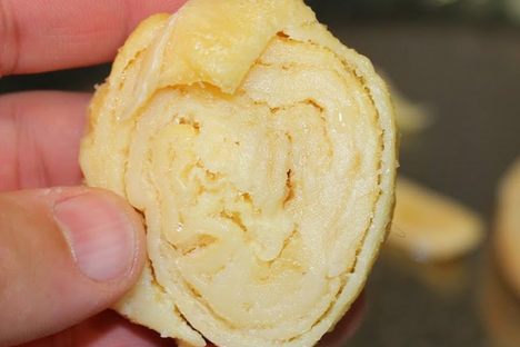 A rolled up ball of sagí, about to be dunked in flour and added to a stew.