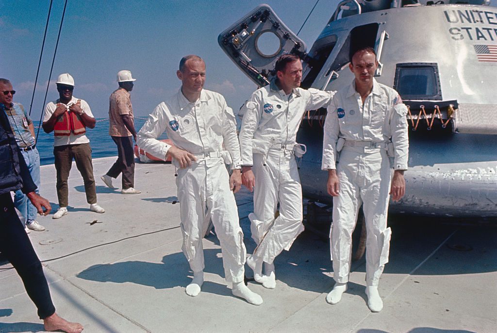 Buzz Aldrin, Neil Armstrong, and Michael Collins in front of one of their training capsules. 