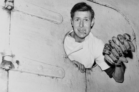 A sailor leans out of a porthole on the SS Tilapa, the first ship to bring bananas into Britain after the Second World War, at Avonmouth Dock, Bristol.