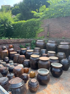 Several dozen earthen pots sit in a coutyard