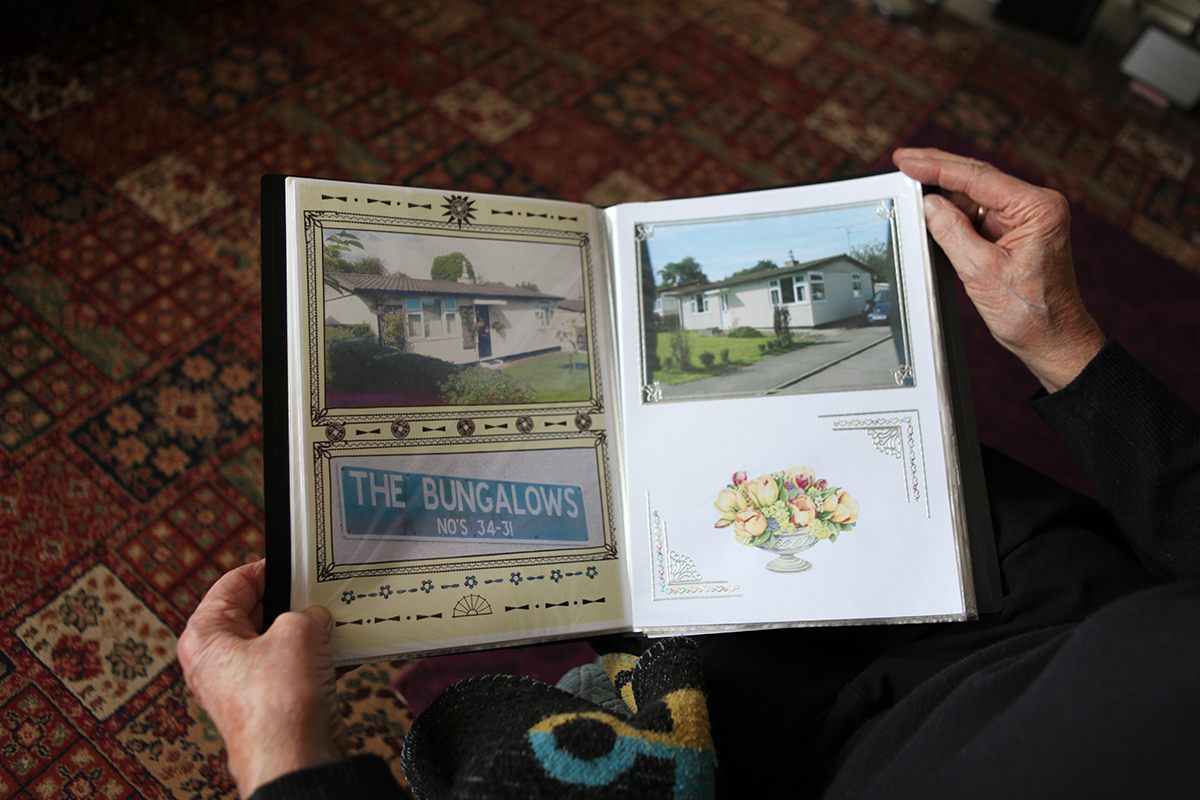 A prefab resident showing his album of photos of prefabs on the Killarmarsh Estate, North Derbyshire, 2013.