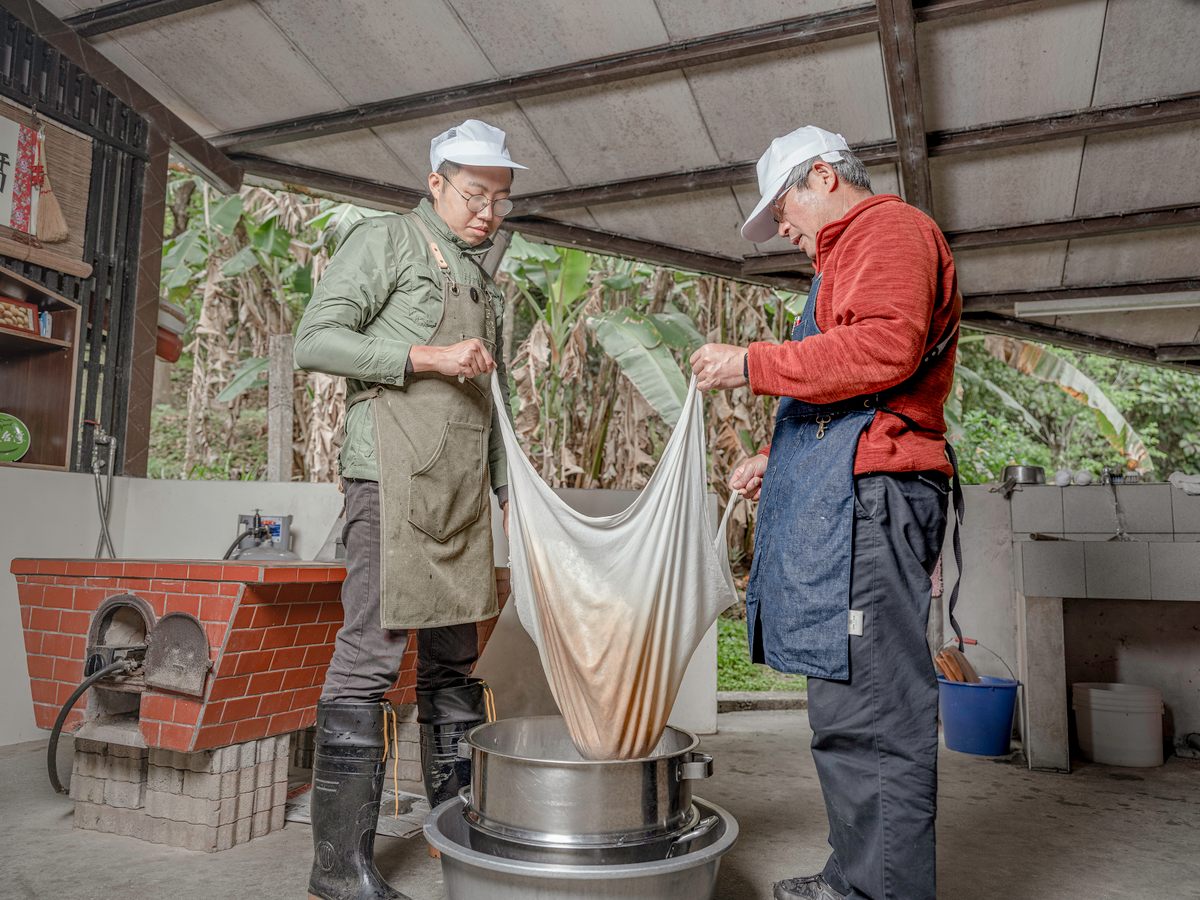 Chang Shun-Hsing and Lin Yih-Cheng filter the soy milk.