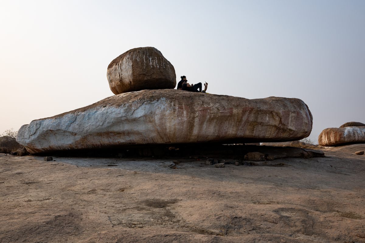 People on a rock called the Spaceship at Khajaguda Hills.