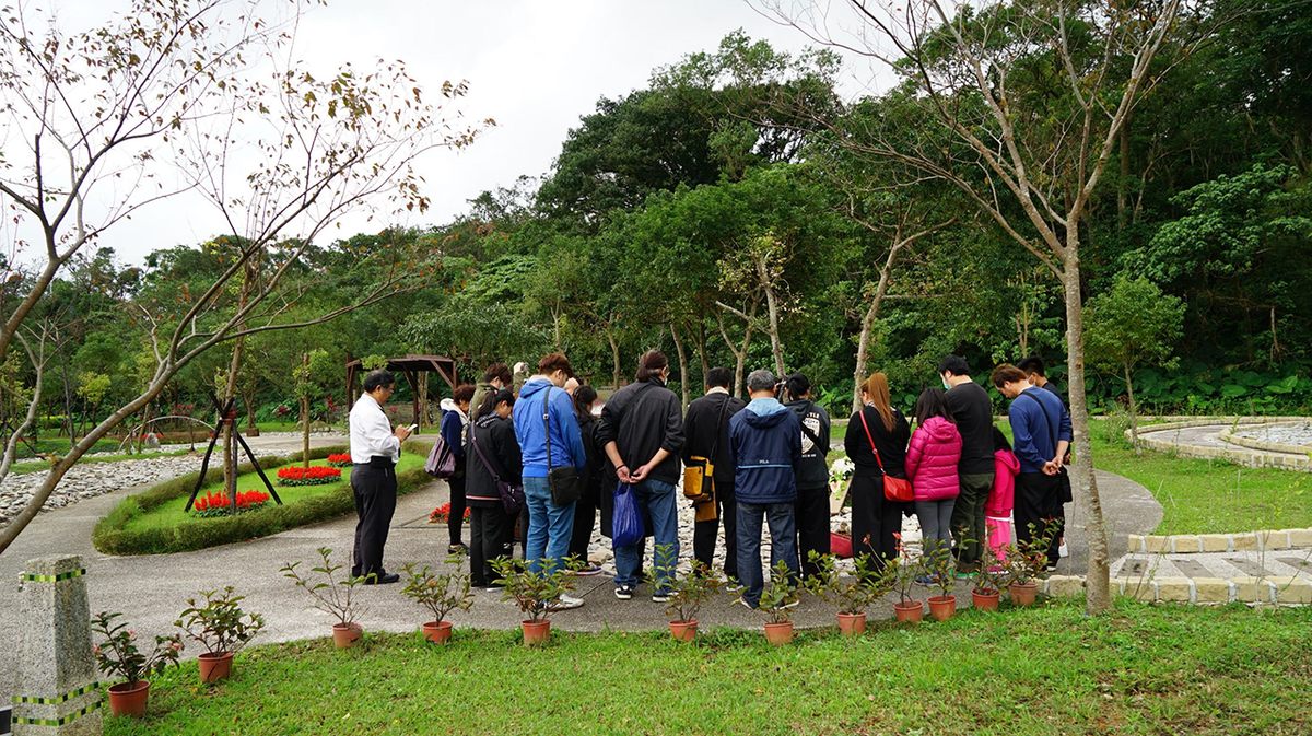People gathered around a tree burial service.