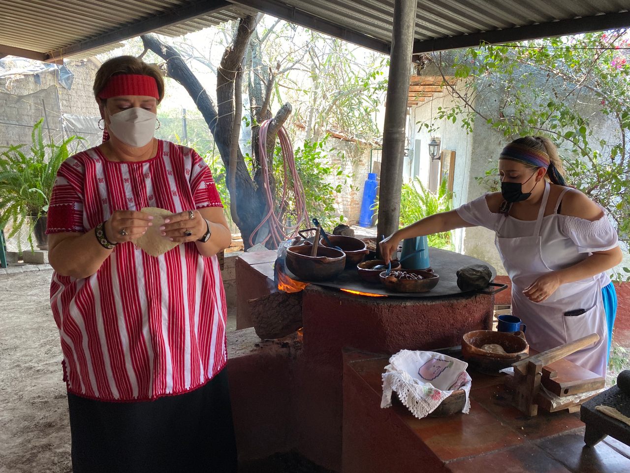 Maru Toledo and one of the "Mujeres del Maíz" make tortillas.