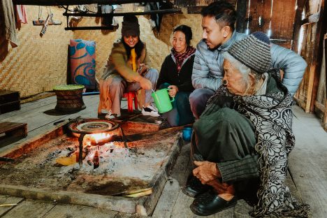 An Apatani family and guests make tapyo around the hearth.