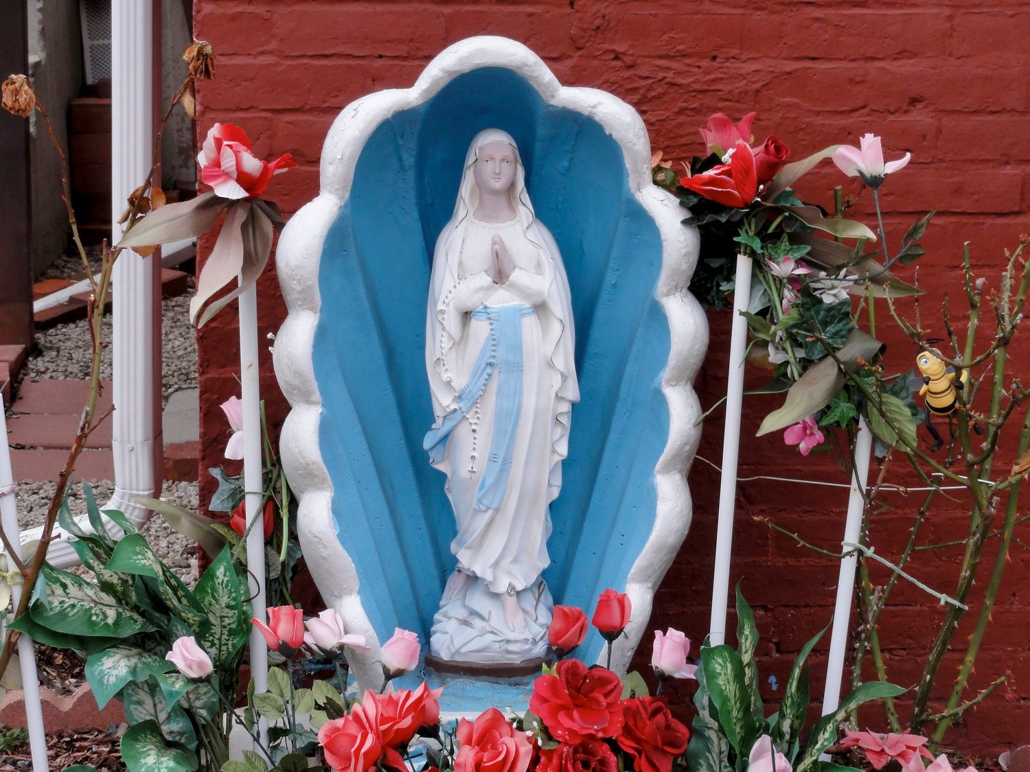 A Mary on the half shell, decked out with artificial flowers.