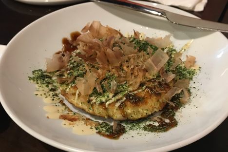A seafood okonomiyaki topped with bonito flakes