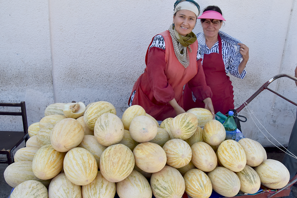 Two vendors at the Bukhara bazaar sell melons. 