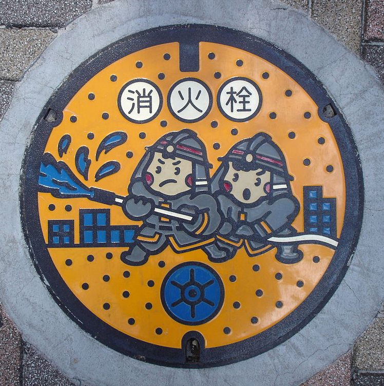 A manhole cover in Tokyo depicting "fireboys."