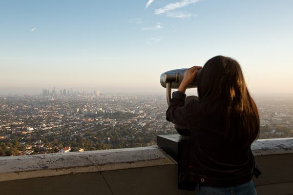 A woman looks through a tower viewer at Griffith Observatory in Los Angeles.