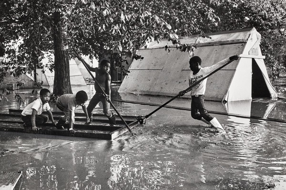 Children rafting between tents in Resurrection City after a flood.