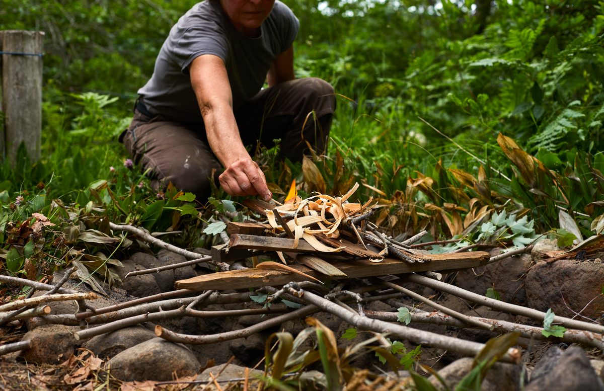 Make a lattice of green sticks across the mouth of the pit, create a “cob-house,” of dry sticks atop it, and set that alight.