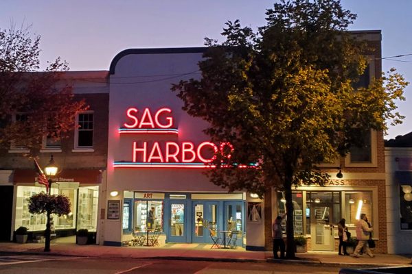 The Art Deco neon sign of the Sag Harbor Cinema at dusk.