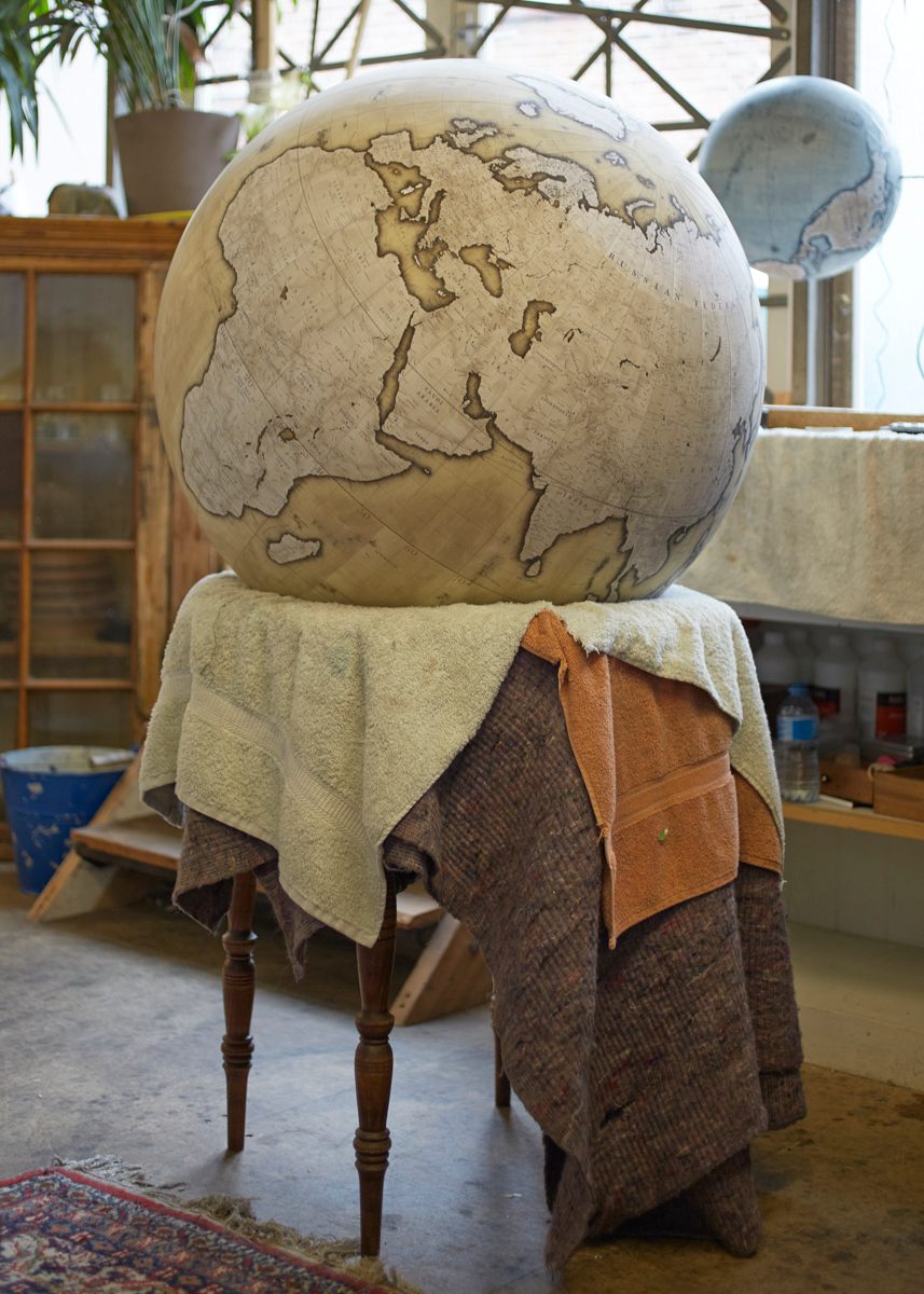  An 80cm handcrafted and hand painted globe in progress, the ocean have been painted, then the shading around the continents, now further detail will be painted in the continents along with final washes of colour because the globe is placed on a handcrafted wood or metal base and shipped off to its new home, photo by Tom Bunning. 