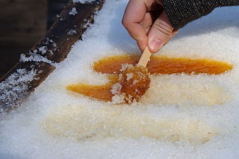 Rolling ready strips of sugar on snow onto popsicle sticks. 