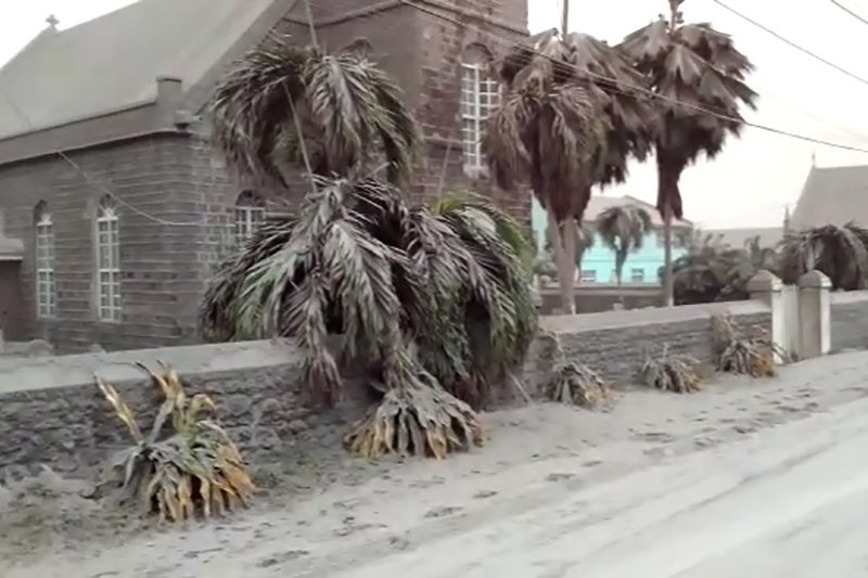 Ash covers palm trees and a church after the April 9, 2021, La Soufrière eruption in St. Vincent. 