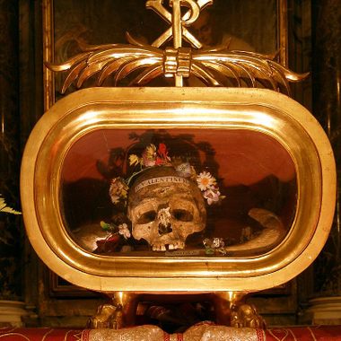 The skull is flanked by flowers.